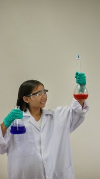 Asian little girl holding test tube or laboratory flask . Education concept.