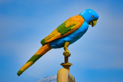 Statue of a parrot posing over a waterfall