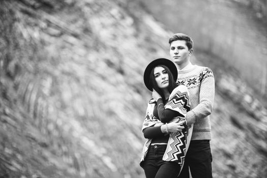 guy and girl in warm sweaters walking along a mountain river, love story