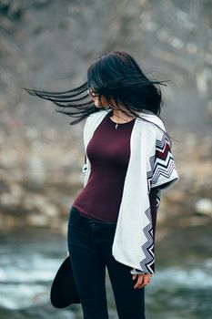 girl in warm sweater walking along a mountain river, love story