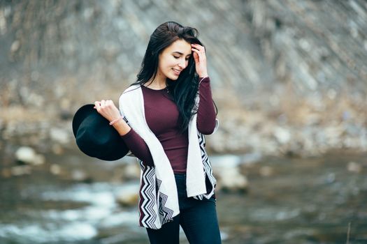 girl in warm sweaters walking along a mountain river, love story