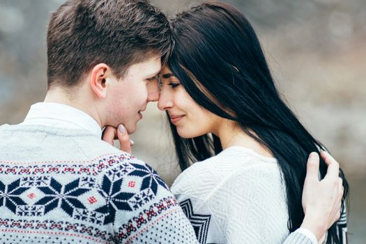 guy and girl in warm sweaters walking along a mountain river, love story