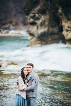 Сouple of newlyweds in the Carpathian waterfall, a wedding walk