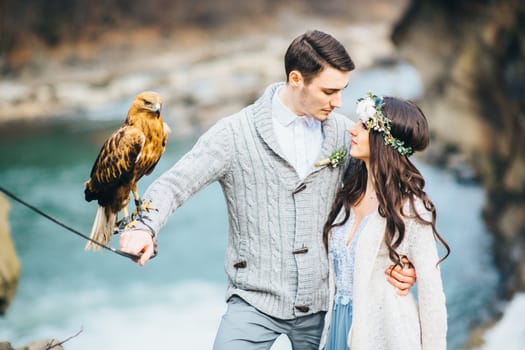 Сouple of newlyweds in the Carpathian waterfall, a wedding walk