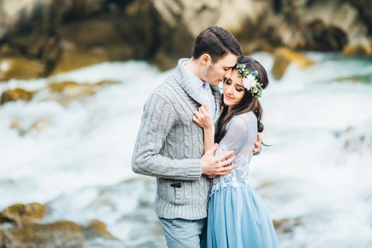 Сouple of newlyweds in the Carpathian waterfall, a wedding walk