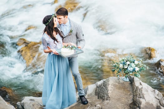 Сouple of newlyweds in the Carpathian waterfall, a wedding walk