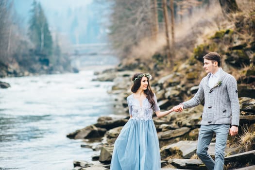 Сouple of newlyweds in the Carpathian waterfall, a wedding walk