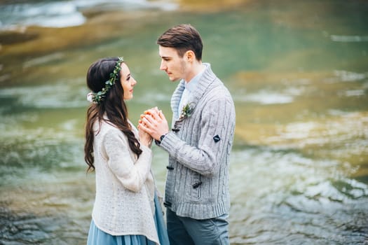 Сouple of newlyweds in the Carpathian waterfall, a wedding walk