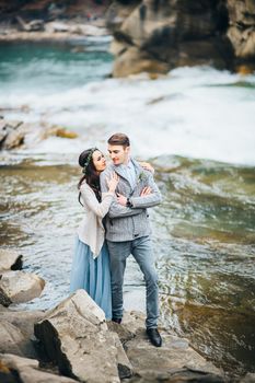 Сouple of newlyweds in the Carpathian waterfall, a wedding walk