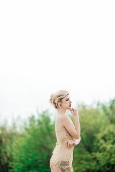 model girl dress gold angel posing in the woods near the old columns