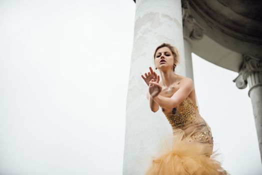 model girl dress gold angel posing in the woods near the old columns