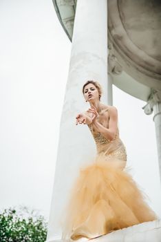 model girl dress gold angel posing in the woods near the old columns