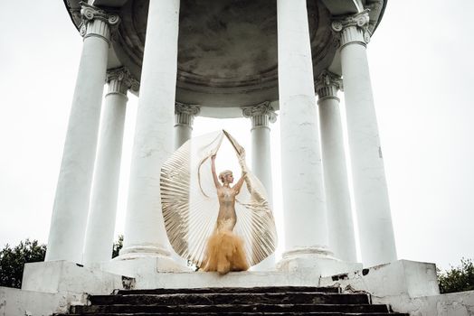 model girl dress gold angel posing in the woods near the old columns