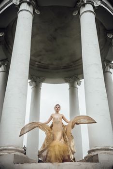 model girl dress gold angel posing in the woods near the old columns