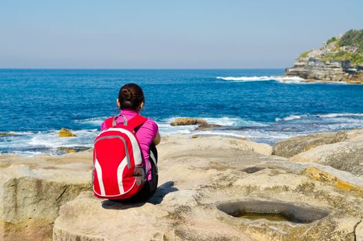 Young woman seen from behind oceanfront of bondi beach , Sydney,Australia.