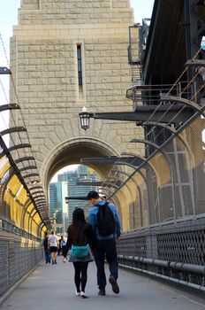 Young couple walking on the popular pedestrian walkway on the Sydney Harbour Bridge in Australia