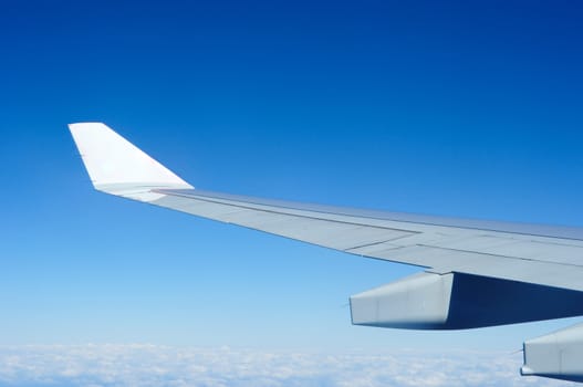 Plain wing over blue sky , travel on the plain.