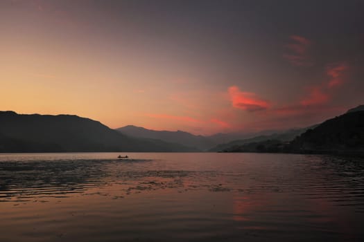 
Sunset on a mountain lake with a small boat