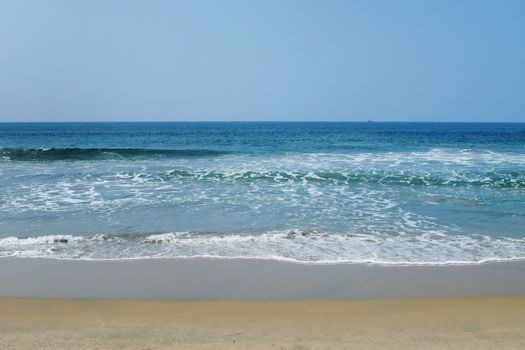 Indian Ocean in calm weather with small waves and smooth sand