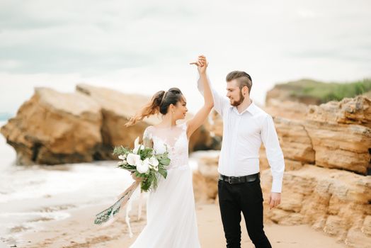 young couple groom with the bride on a sandy beach at a wedding walk