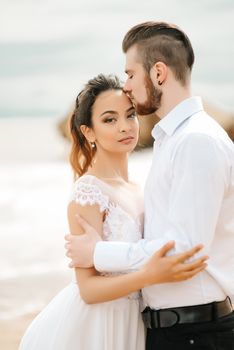 young couple groom with the bride on a sandy beach at a wedding walk