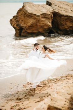 young couple groom with the bride on a sandy beach at a wedding walk