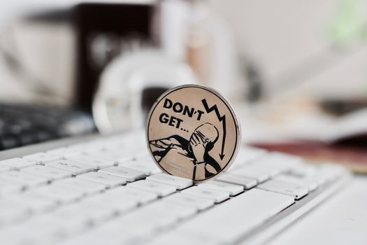 Digital currency physical metal bitcoin coin on the white keyboard near glass ball.