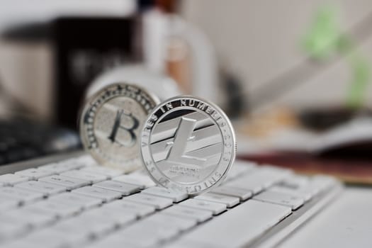 Digital currency physical metal bitcoin coin on the white keyboard near glass ball.