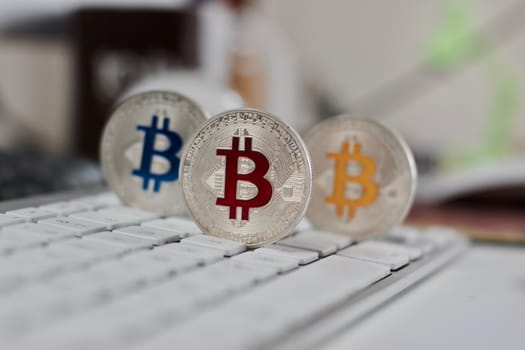 Digital currency physical metal bitcoin coin on the white keyboard near glass ball.