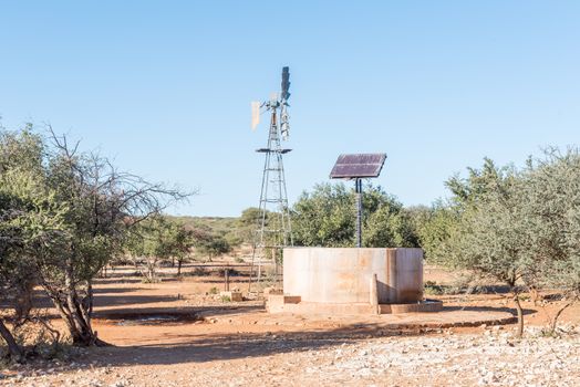 A water-pumping windmill and solar panels for a waterpump near Schmidtsfrift, a village in the Northern Cape Province of South Africa