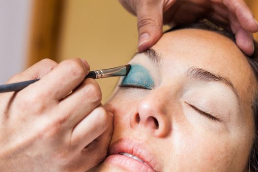 Make up artist applying eyeshadow to a woman