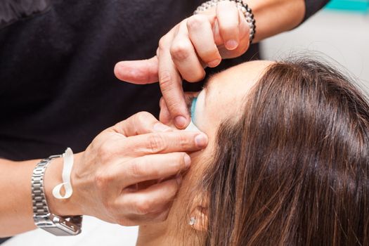 Make up artist using masking tape to create cat eyes