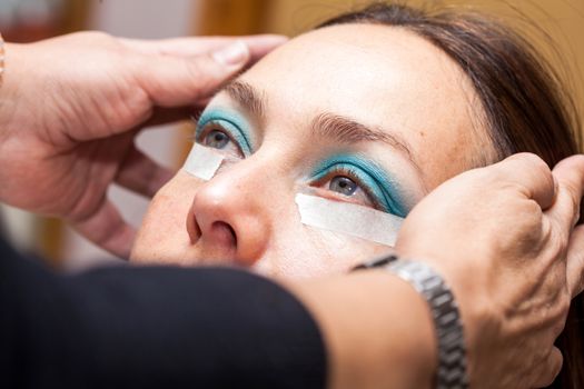 Make up artist using masking tape to create cat eyes