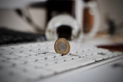 Physical coin polish money on the white computer keyboard.