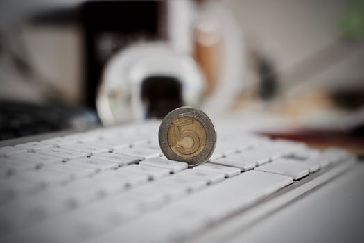 Physical coin polish money on the white computer keyboard.