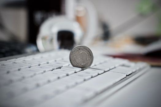 Physical coin polish money on the white computer keyboard.