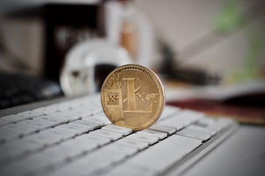 Digital currency physical litecoin coin on the white keyboard. Computer concept.
