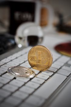 Digital currency physical litecoin coin on the white keyboard. Computer concept.