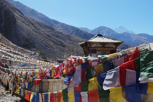 The Buddhist monastery is high in the mountains with a large number of flags, near Muktinath