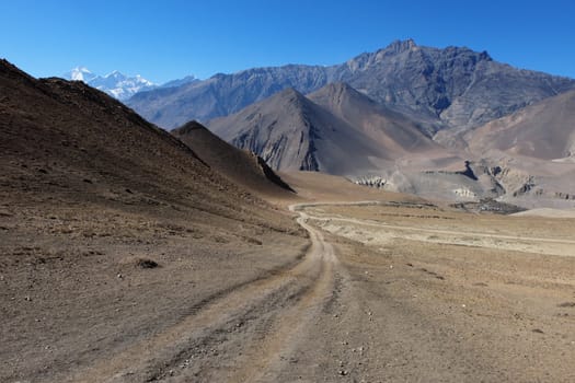 Mountain road in the Himalayas at an altitude of 4,500 meters with a mountain nilgiri in the background.