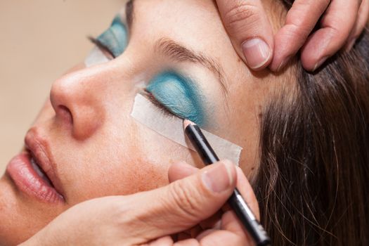 Make up artist using masking tape to create cat eyes