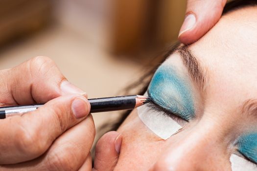 Make up artist using masking tape to create cat eyes