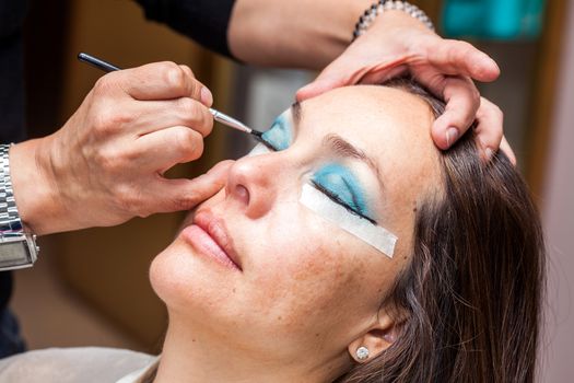 Make up artist using masking tape to create cat eyes