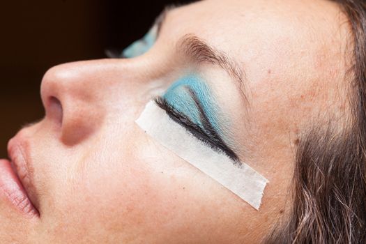 Close up of a woman while make up artist creates cat eyes