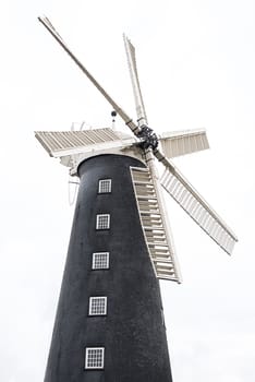 A half length upright photograph of a windmill with six sails isolated on a white background