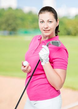 young brunette loves to play golf, posing on a background of golf courses