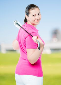 brunette with club golf posing on a background of golf courses