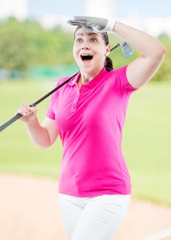 athlete woman watching the ball flight path of golf on a background of golf courses