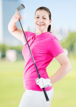 girl with a golf club in a pink polo shirt on a background of golf courses