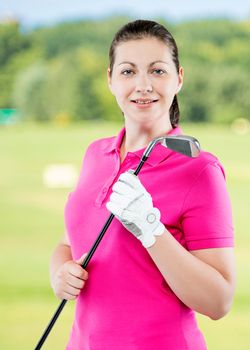 Happy successful golfer posing on a background of golf courses